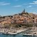 A marina and the Notre-Dame de la Garde basilica on top of a hill in Marseille, France